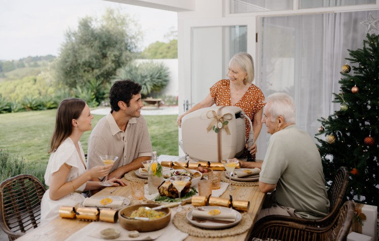woman being given an Evolve™ hose reel at Christmas surrounded by family