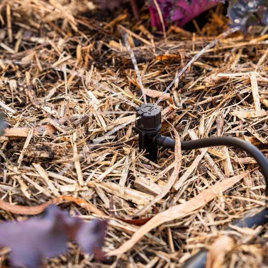 180° Adjustable Drip Head installed in mulch watering a garden bed