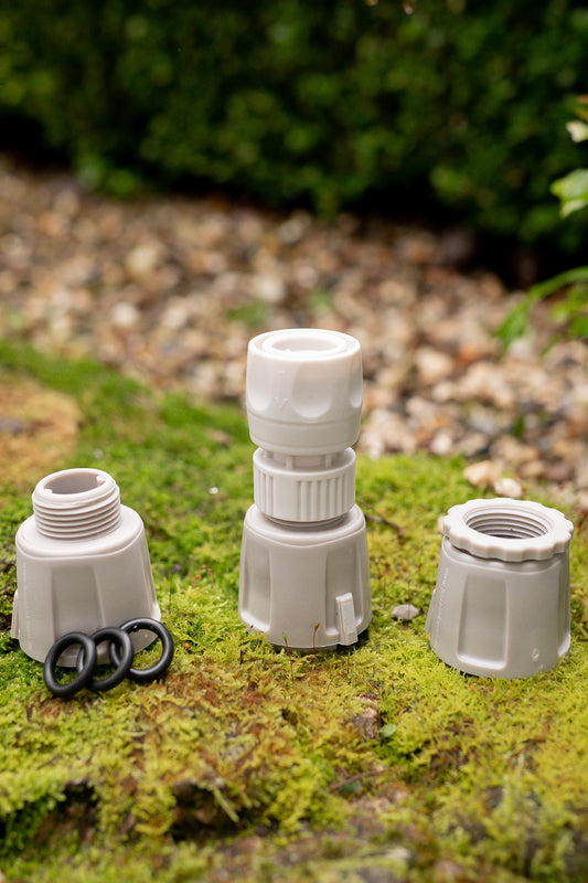 Beige Connectors from the Hoselink Adapter Pack sitting on mossy surface in garden