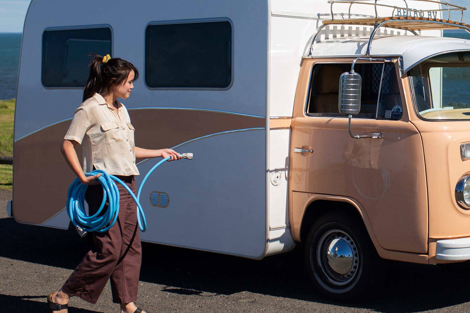 Woman Using Blue Drinking Water Hose To Water Her Caravan