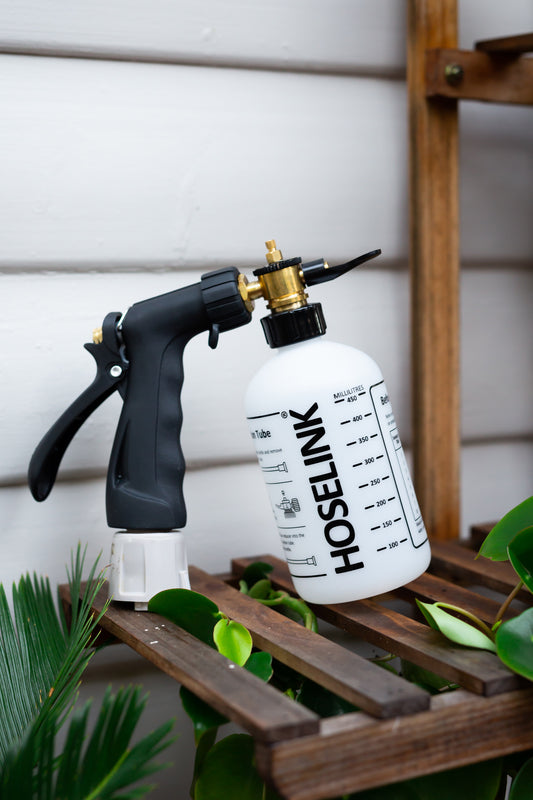 fertiliser spray mixer on timber shelf with plants surrounding it