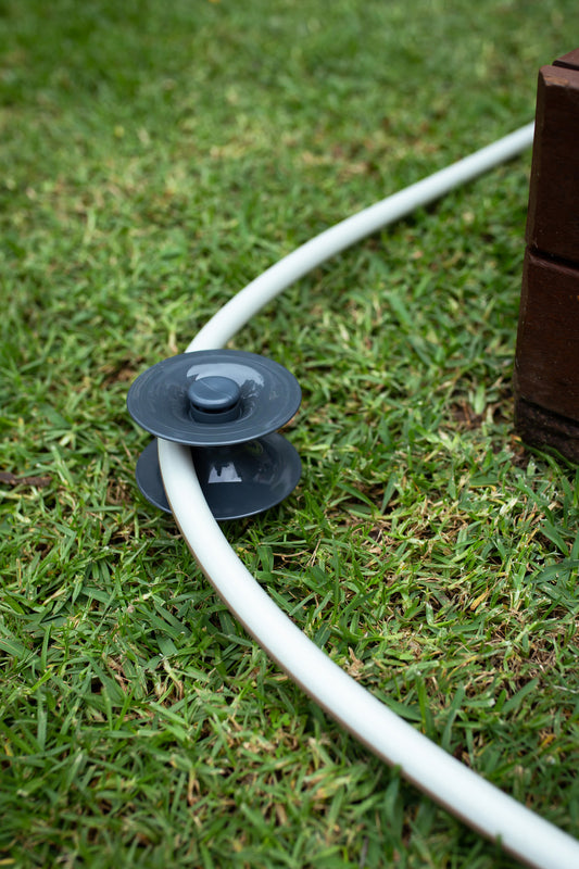 Ground Hose Guide Resting On Grass With Hoselink Hose Swivelled Around It