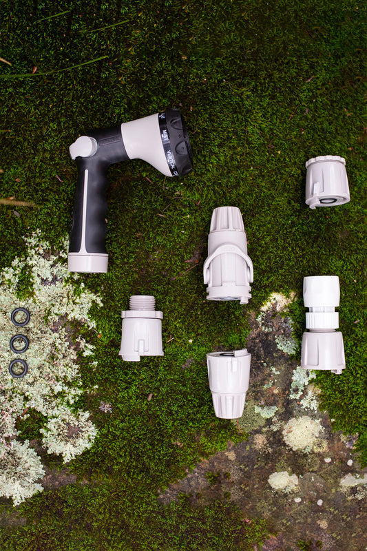 Flatlay of Hoselink's Beginners Basic Pack including spray gun and hose connectors on mossy background