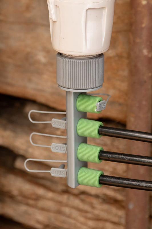 Mini Sprinkler Kit 4-Way Outlet attached to garden tap and three tubes, with one valve blocked off with the stop tab