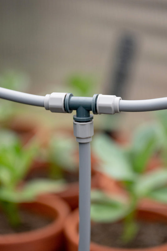 Close-up of Misting Kit T-Joint part connected to misting tube in all directions inside a greenhouse