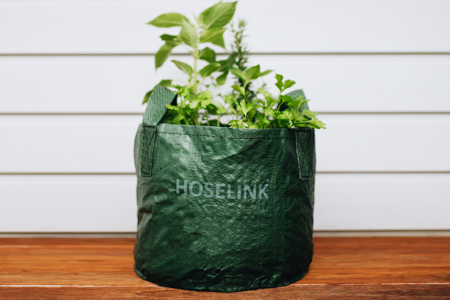 planter bag with herbs inside on a deck