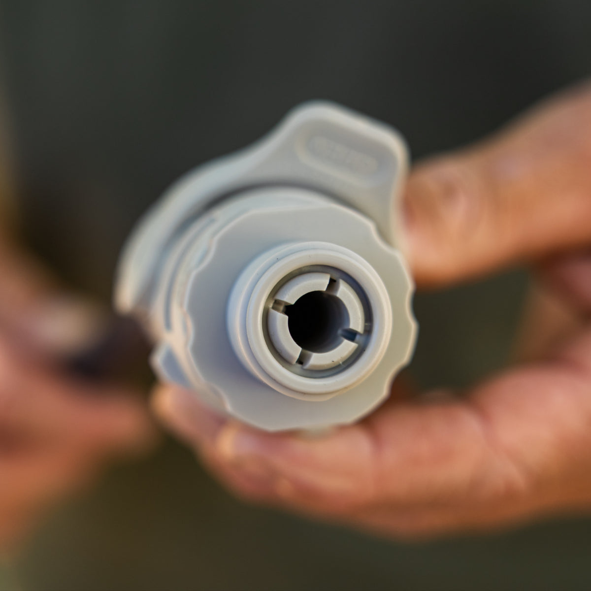 A close-up of the internal grey stem on a accessory conenctor gen 2 being held by blurred hands in the background