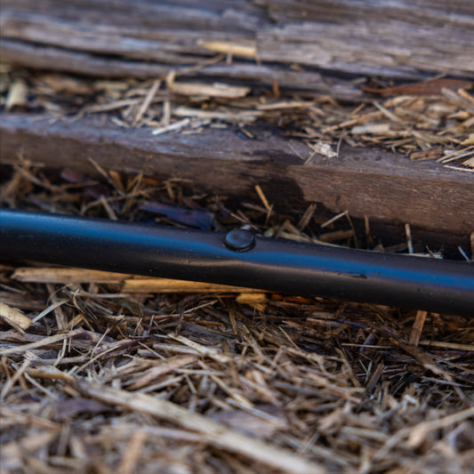 Goof plug installed into black irrigtion tubing on straw mulch to block a hole