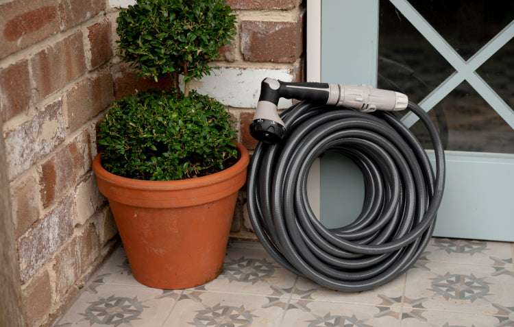 manual garden hose coiled up on doorstep