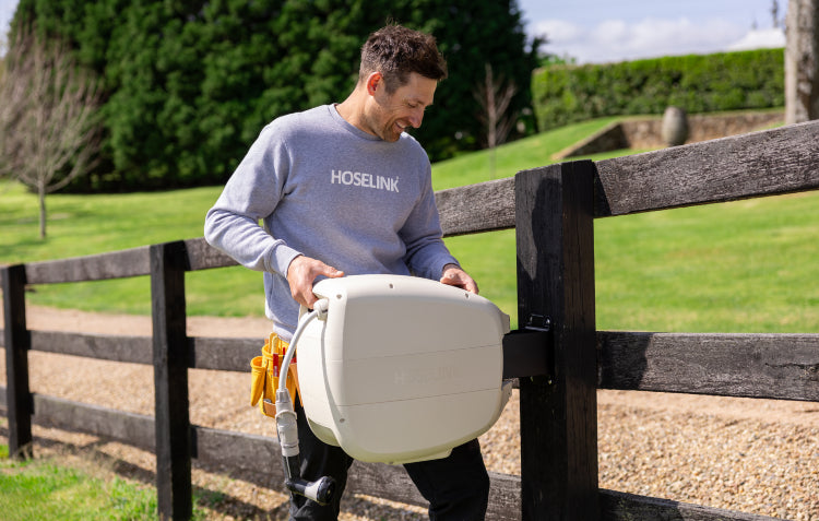 Installer placing Evolve™ Hose Reel on Timber