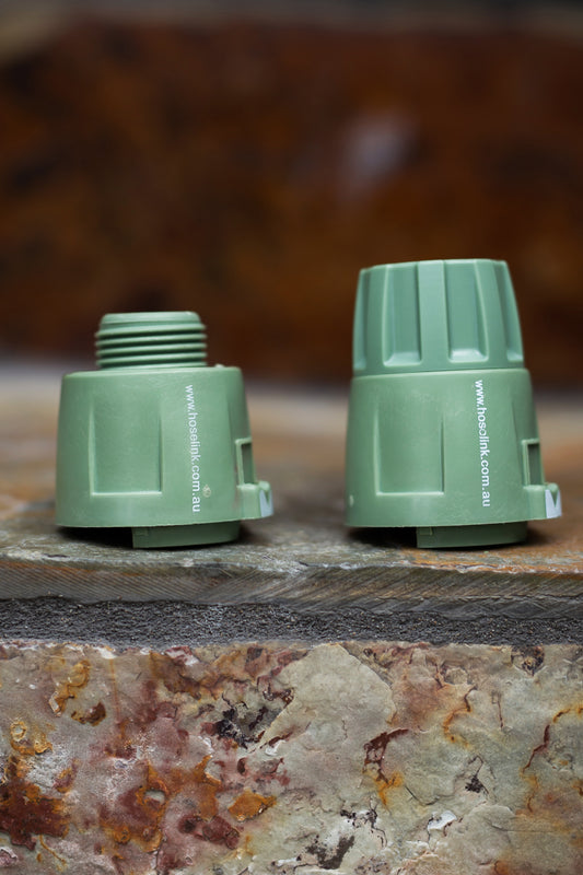 Light Green Accessory Connector and Hose End Connector standing upright on brown marbled stone step. 