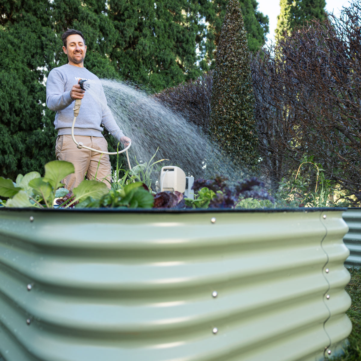 Ben Hayman watering vegetables in a 6 in 1 Garden Bed.