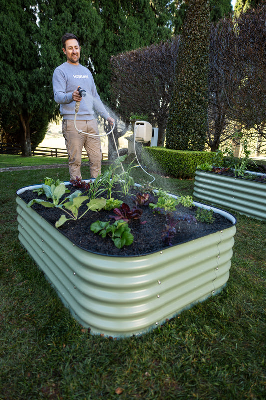 Ben Hayman watering vegetables in a 6 in 1 Garden Bed.