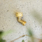 Brass angled tap adaptor lying on a stone background