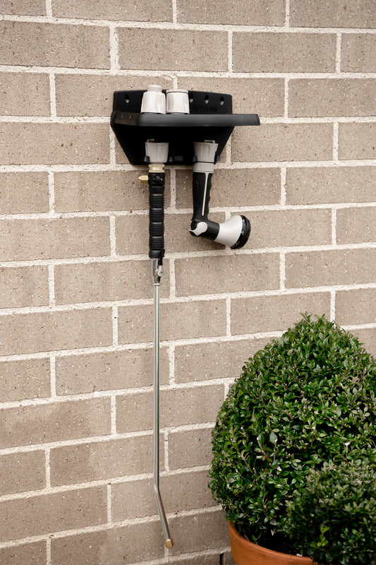 Black Handy Shelf mounted to brick wall with connectors and watering accessories on display