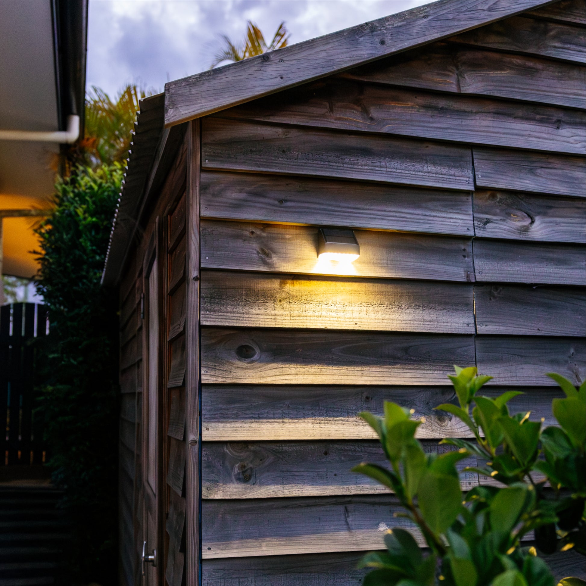 Compact Soalr Flood Light mounted on a brown, wooden weatherboard shed