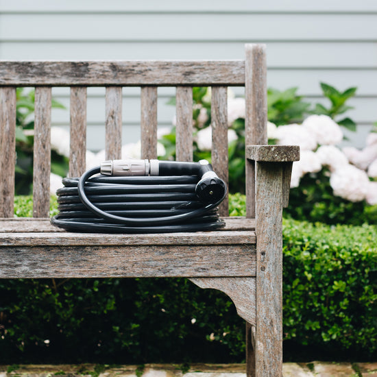 Charcoal Superflex Hose coiled neatly on a garden bench outside