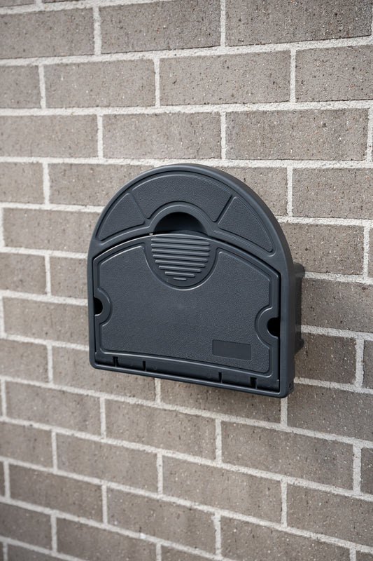 Charcoal Handy Hose Hanger mounted to grey brick wall