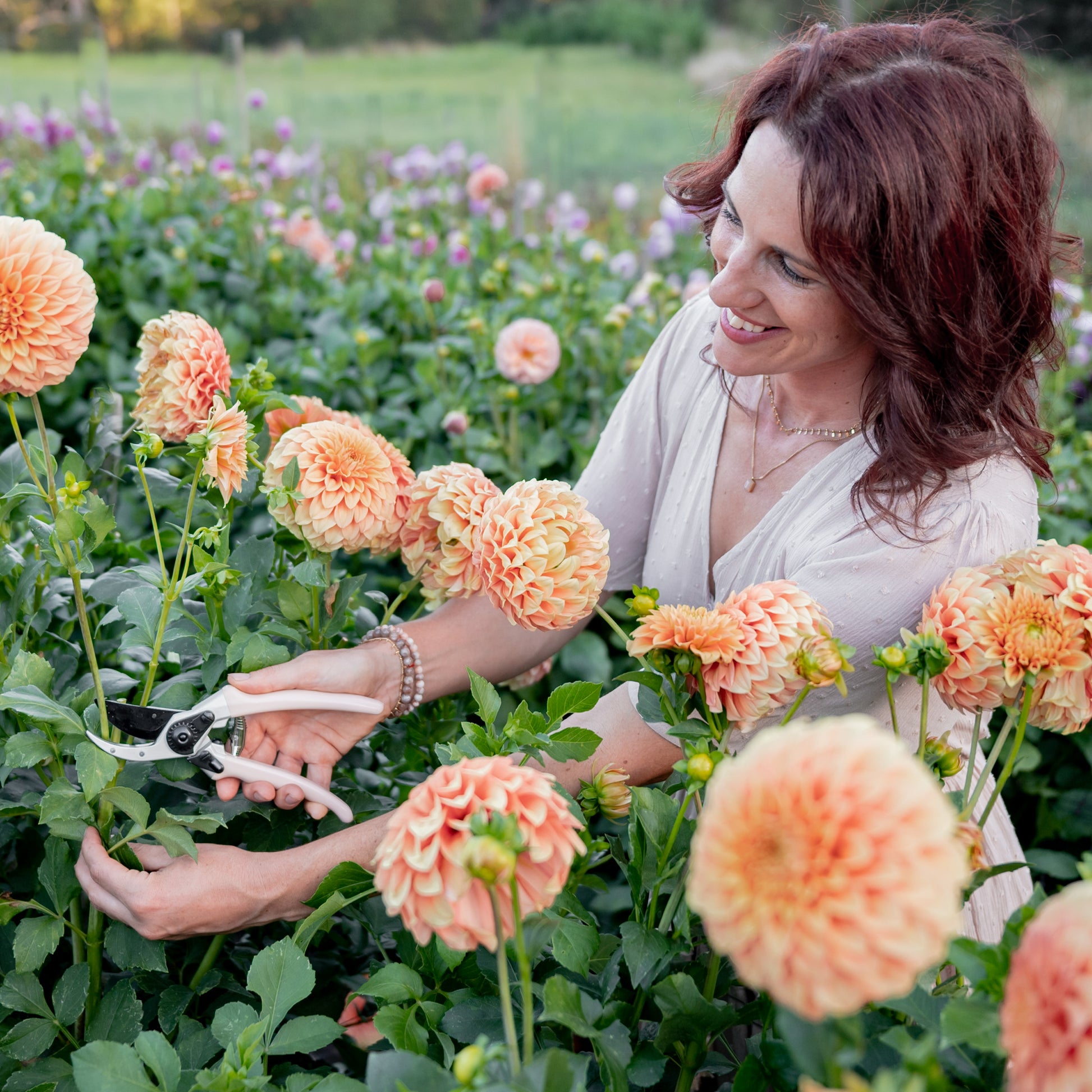 woman cutting flowers with peach secateurs