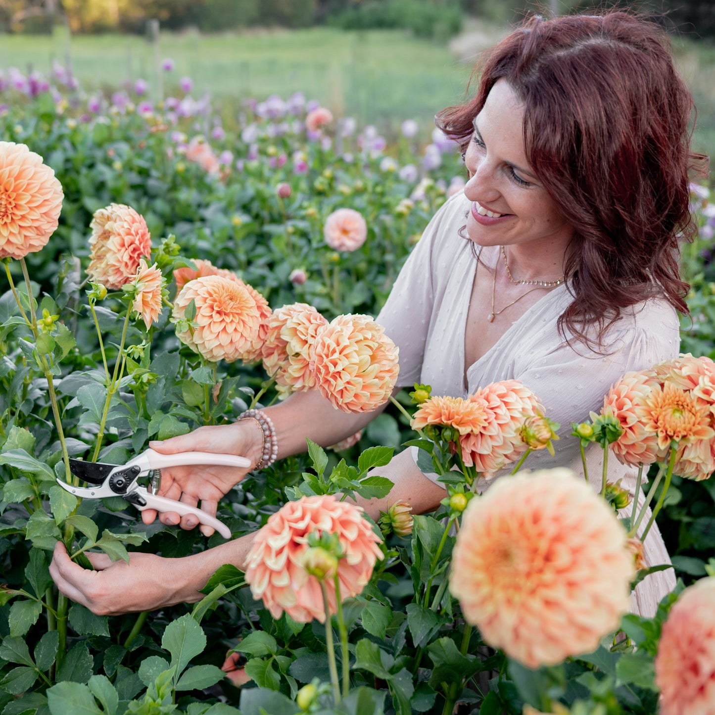 woman cutting flowers with peach secateurs