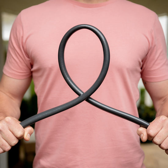 Male holding the Charcoal Superflex Garden Hose twisting it into a loop in front of him