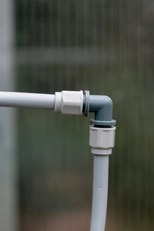 Misting kit L-joint connected to misting tube at both directions in a greenhouse