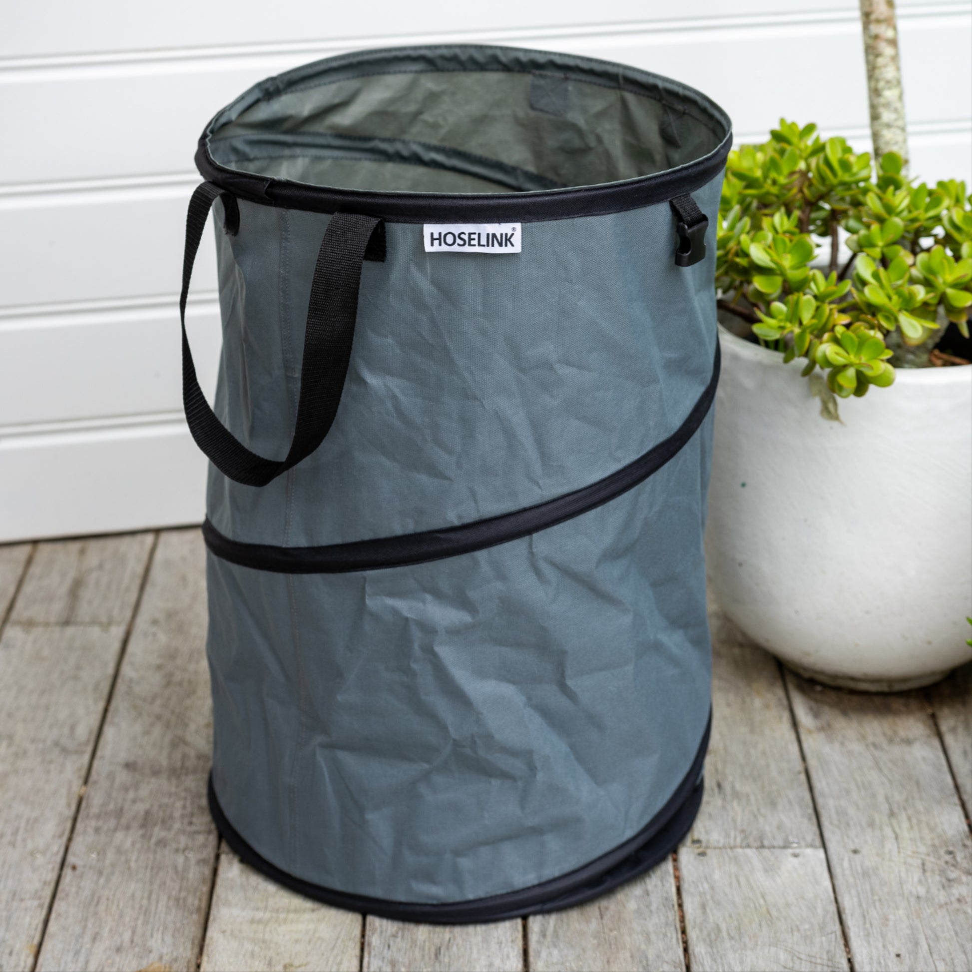 Empty charcoal coloured garden waste back sitting on timber deck