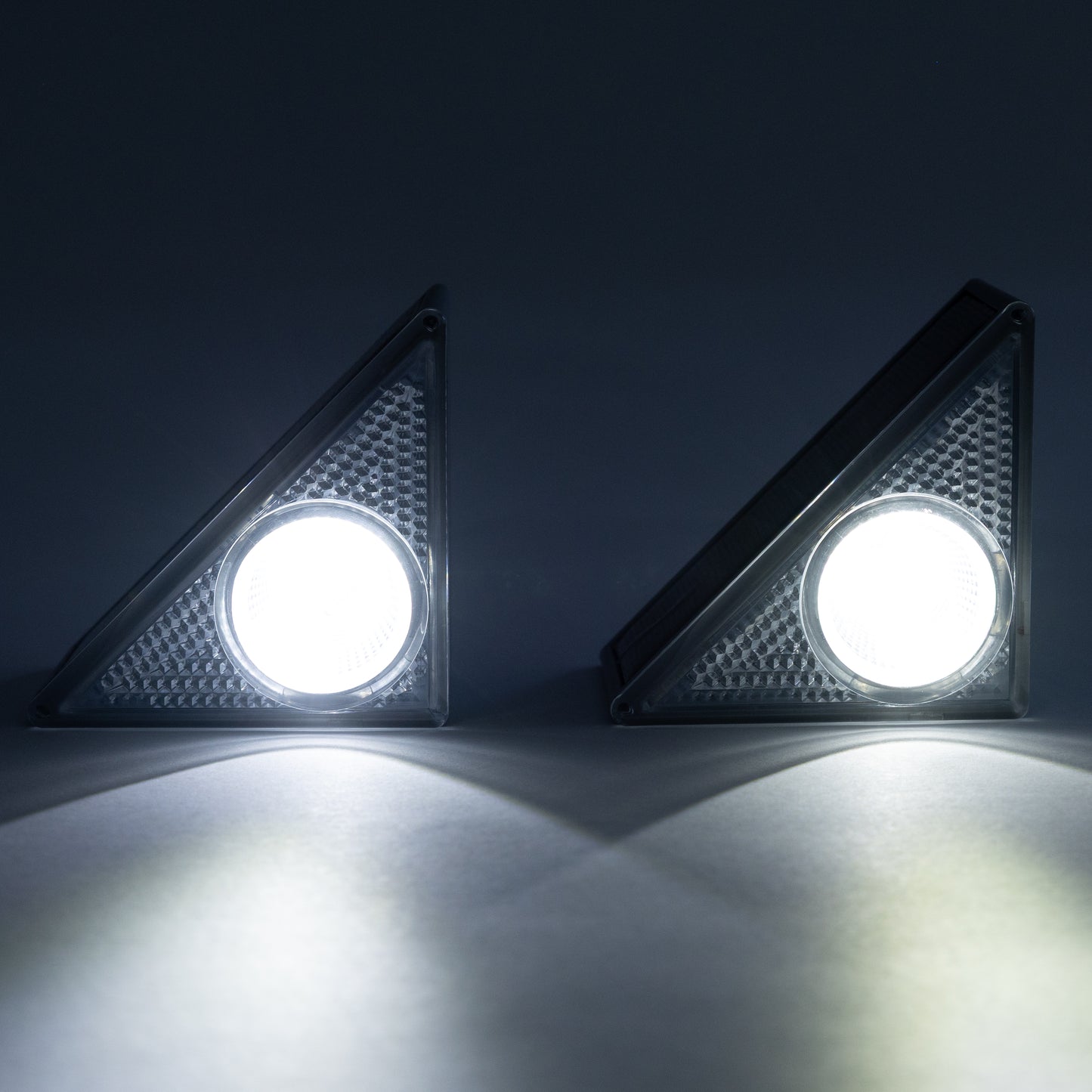Two solar step LED lights on a dark background with light on