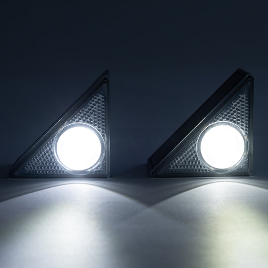 Two solar step LED lights on a dark background with light on