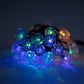 String of green and blue colored bauble lights on a dark background