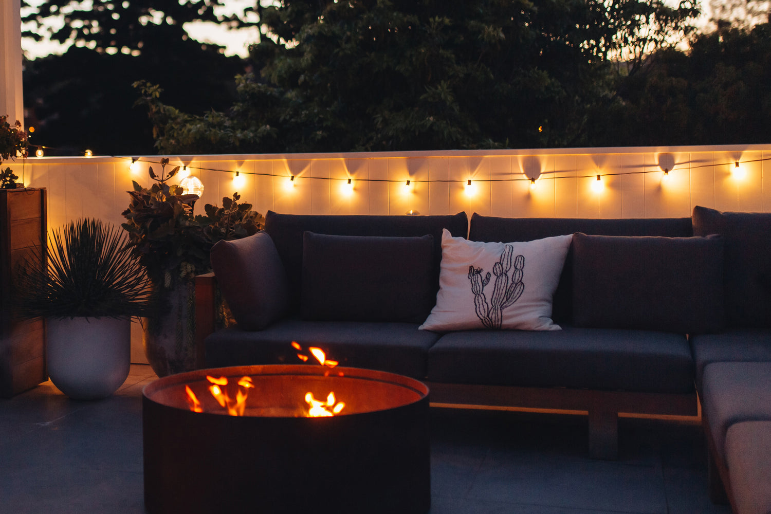 Warm white solar festoon lights hanging on balcony wall by outdoor lounge area