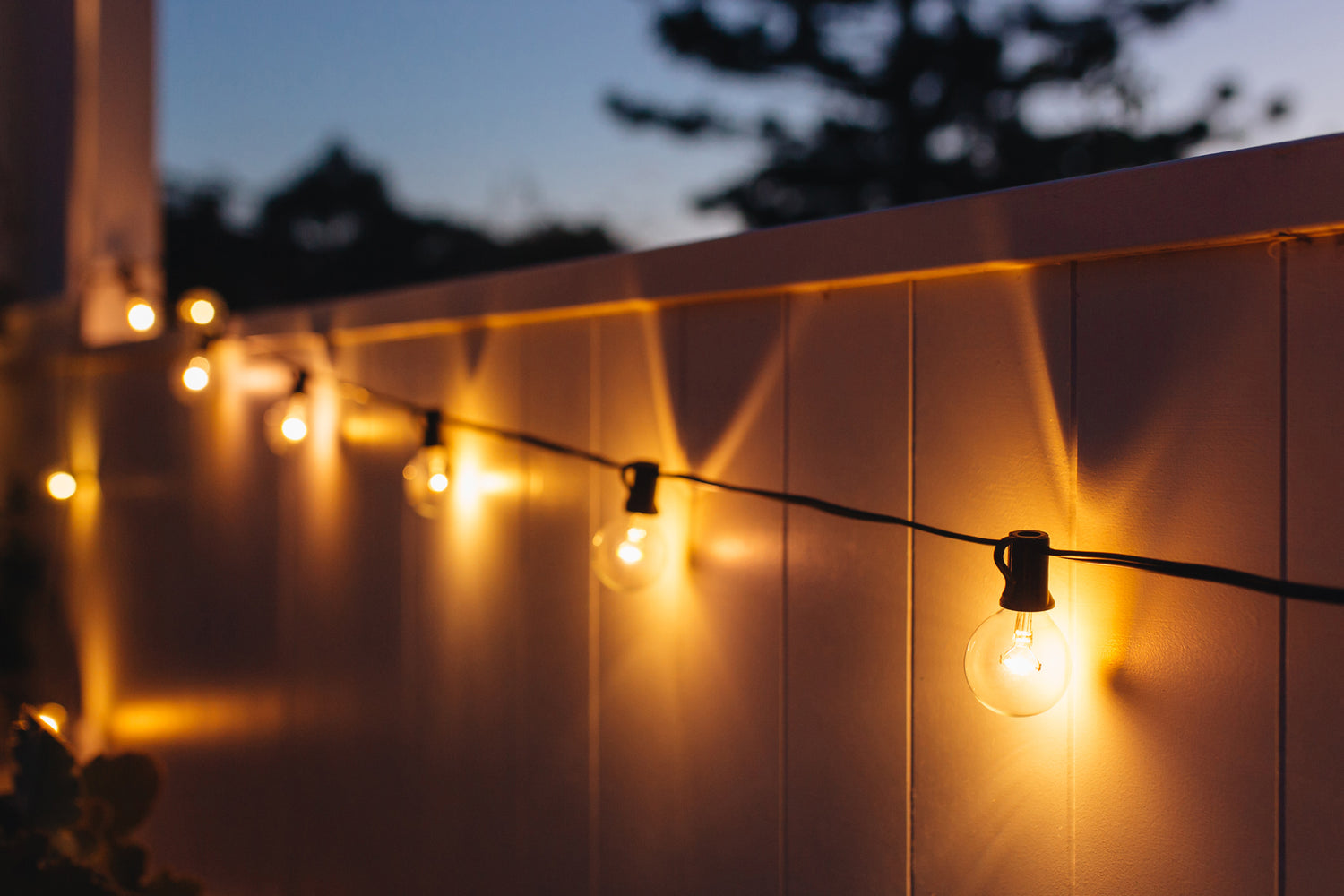 Close-up of warm white solar festoon lights strung along a balcony wall