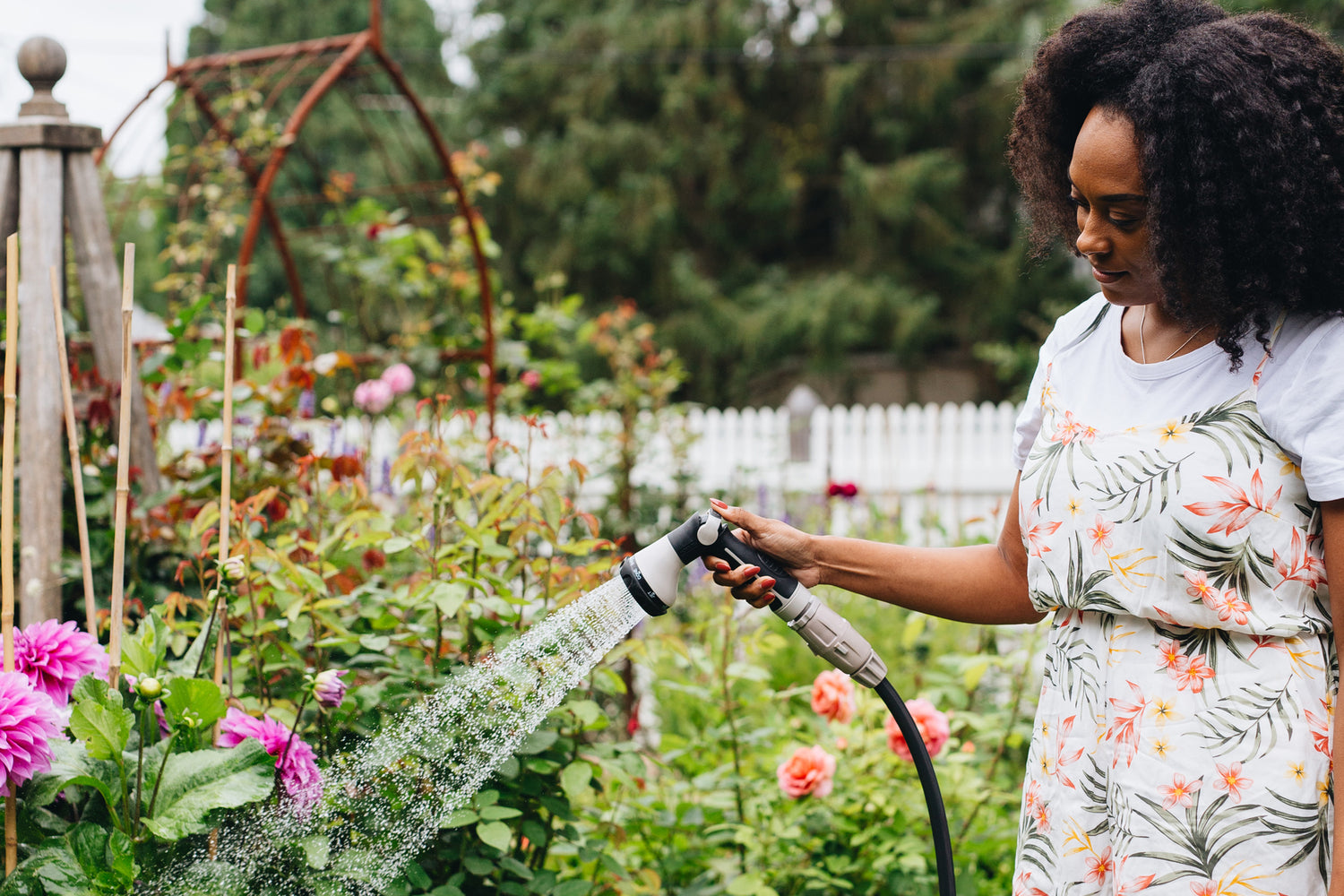 Female watering with charcoal-coloured Superflex Garden Hose in flower garden