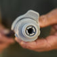 A close-up of the internal grey stem on a accessory conenctor gen 2 being held by blurred hands in the background