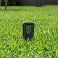 Soil meter turned on inserted into grass.