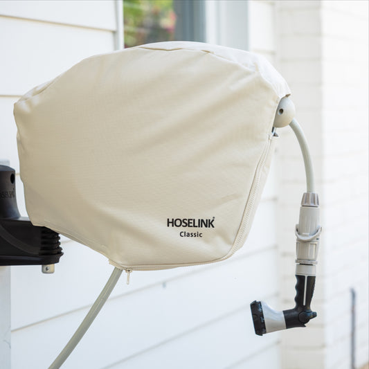 HOSELINK Classic Hose Reel with beige cover installed on a white weatherboard house