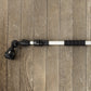 A close-up of a telescoping cleaning system pole with black textured grip sections and 8-pattern sprayer head attachments laid horizontally on a brown wooden plank surface.
