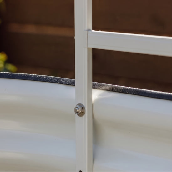 Close up image showing a stainless screw nut and washer attaching a trellis to a garden bed wall. 