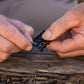 Black goof plack being removed from rack of 10 by hands