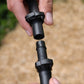 close-up of hands installing a 13mm irrigation joinr to a piece of black poly pipe with ratchet clamps