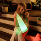 Little girl holding the Tall Solar Santa light, sitting on some wooden stairs. the Tall Solar Santa light is emitting a green glow. 