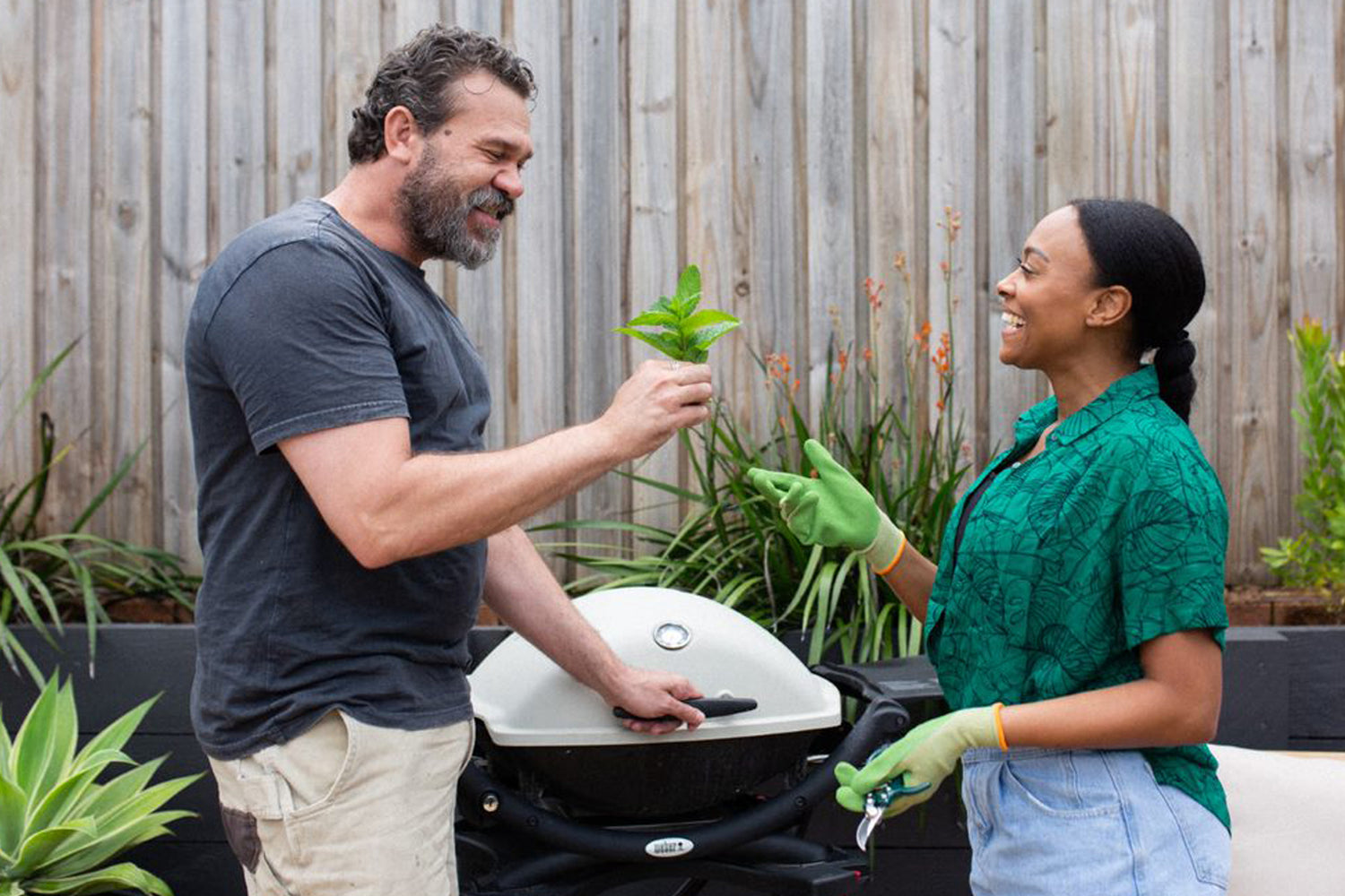 man and woman chatting in front of bbq in the backyard