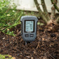 Soil meter turned on, inserted into the dirt.