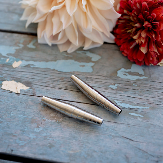 Two silver springs for secateurs on blue wood table next to flowers